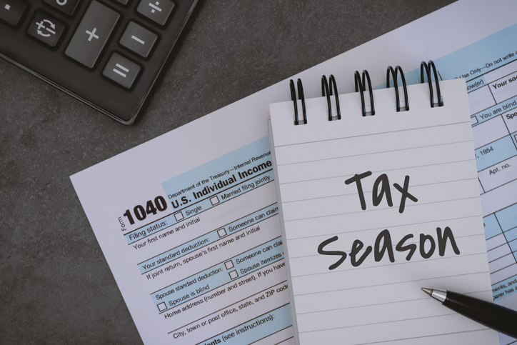 Tax Season Written on Notepad and Printed Tax Form