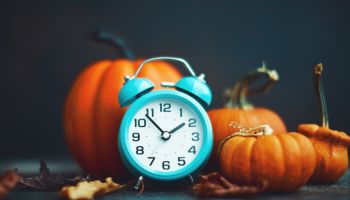 Time for Fall. Teal alarm clock with leaves and Pumpkins