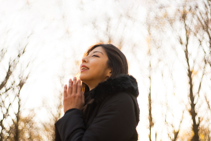 Asian woman praying sincerely with both palms together