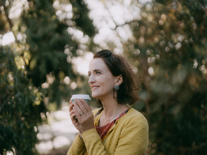 Woman enjoying takeaway coffee in suburb
