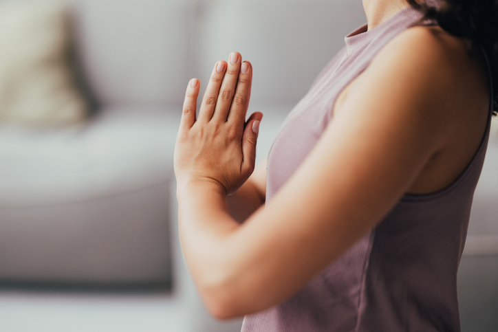 Living Room Workout Session: Anonymous Woman Doing Yoga, with her Palms Joined at Chest