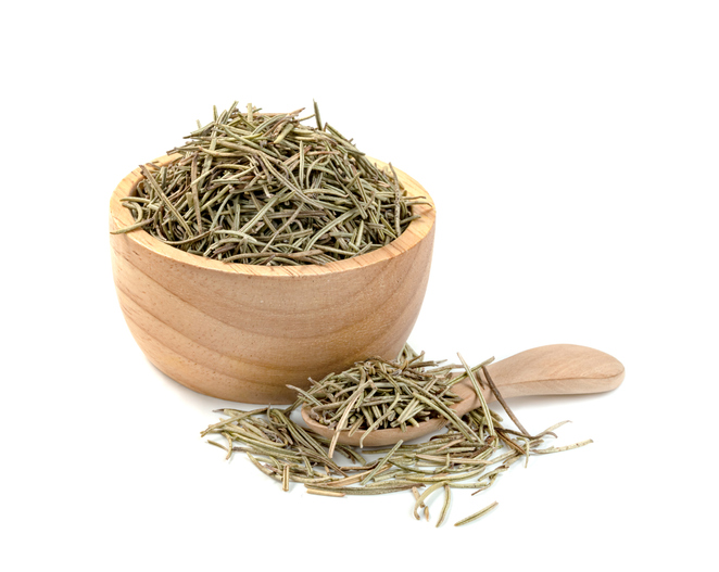 Dry rosemary pile in wooden bowl and spoon isolated on white background