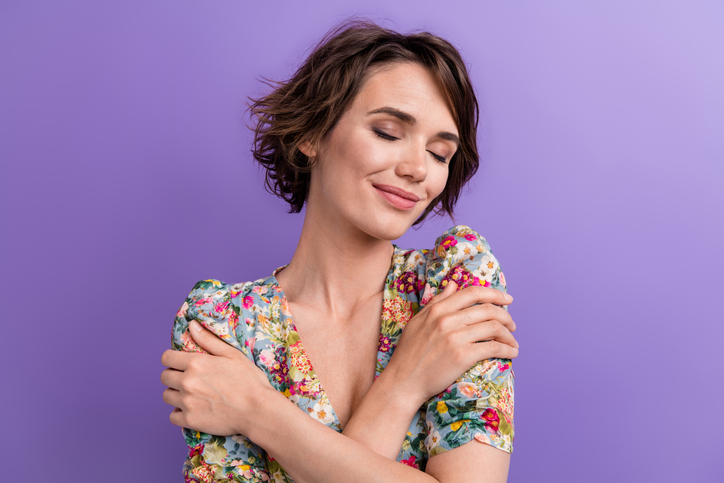 Photo portrait of lovely young lady cuddle embrace shoulders dressed stylish flower print garment isolated on purple color background